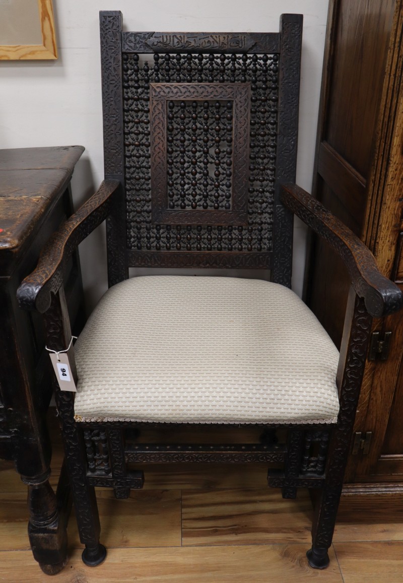 A North African carved hardwood armchair, W.55cm., D.42cm., H.105cm.